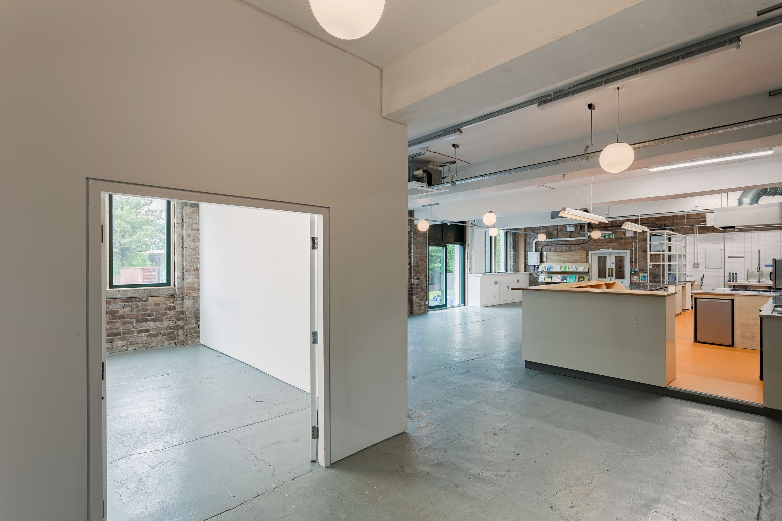 Photo of the project space at Civic House looking towards the canteen. This can be used as the ticket booth and check-in desk for the Festival hub as it is a small white box placed conveniently between the venue and the canteen.