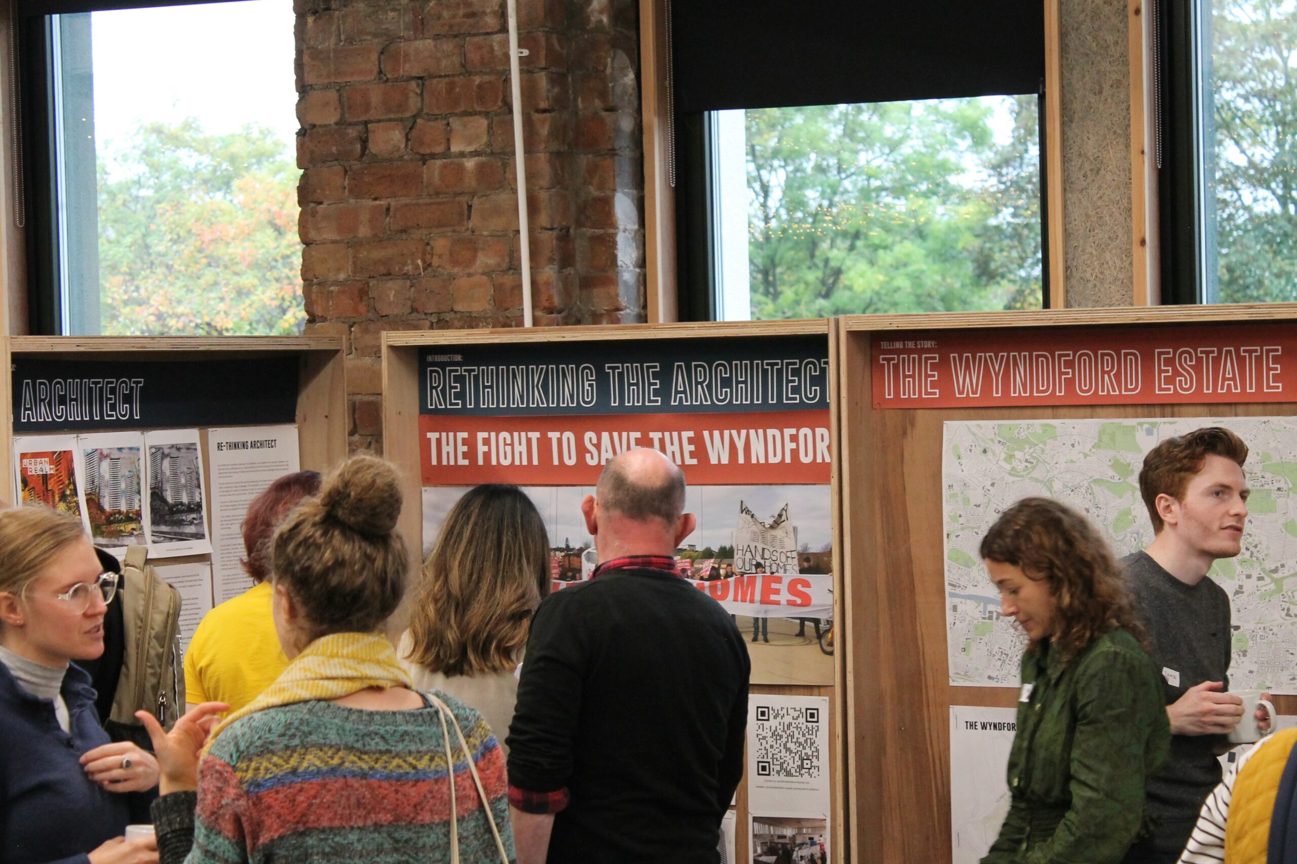 People interact in front of exhibition boards at Civic House Venue